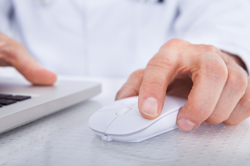Fotografia-closeup-mão-de-doutor-movendo-mouse-sentado-frente-ao-computador